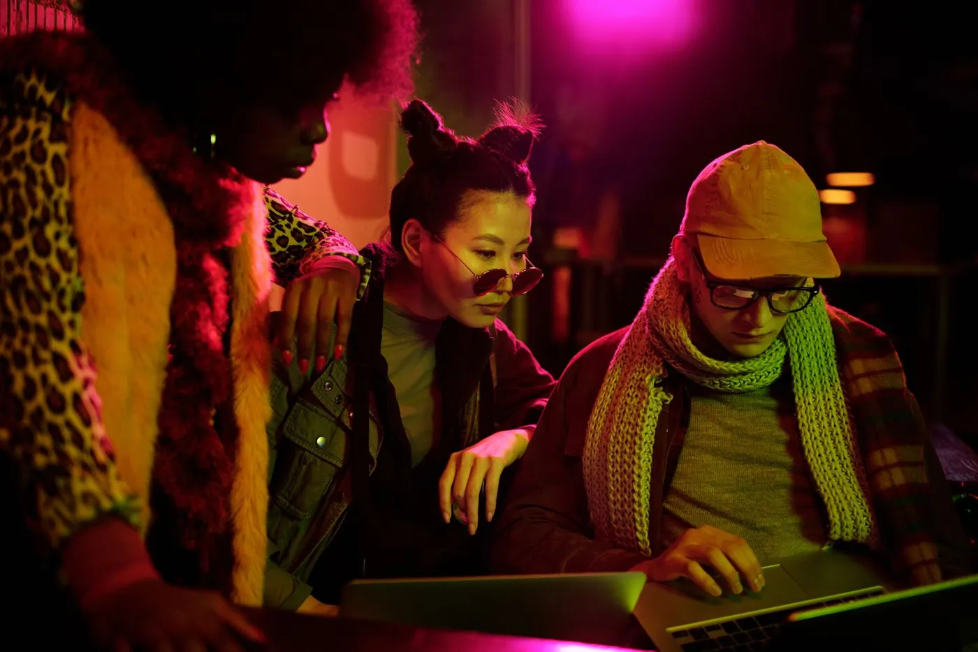 Team working together on laptops in a neon-lit room